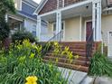 Inviting front porch with swing, brick steps and well-maintained landscaping with yellow flowers at 2620 Merion Hills Ct, Charlotte, NC 28269