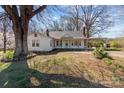 Quaint single-story home featuring a cozy front porch and attached carport, surrounded by mature trees at 28120 Ryan Rd, Richfield, NC 28137