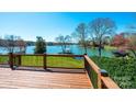 Beautiful lake view from the home's deck with wooden railing overlooking green lawn at 343 River Haven Dr, Taylorsville, NC 28681