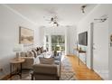 Bright living room with hardwood floors, modern ceiling fan, neutral decor, and balcony access at 3939 Picasso Ct, Charlotte, NC 28205