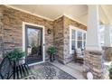 Inviting front porch showcasing stone accents, seating area, and stylish decor, creating a cozy outdoor space at 5115 Sand Trap Ct, Monroe, NC 28112