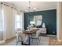 Bright dining room with modern chandelier, neutral chairs, and a stylish accent wall with decor at 6020 Chumbley Point Rd # 73, Charlotte, NC 28215