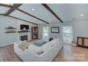 Spacious living room with exposed beams, a fireplace, and a comfortable sofa, perfect for relaxing and entertaining at 6201 Sellars Ct, Charlotte, NC 28211