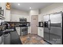 Well-appointed kitchen featuring stainless steel appliances, white cabinets, and stylish backsplash at 6645 Allness Glen Ln, Charlotte, NC 28269
