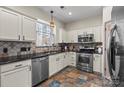 Well-lit kitchen equipped with stainless steel appliances, tile backsplash and stone countertops at 6645 Allness Glen Ln, Charlotte, NC 28269