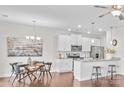 Open-concept kitchen with white cabinetry, stainless steel appliances, granite countertops, and hardwood floors adjacent to dining area at 684 Cape Fear St, Fort Mill, SC 29715
