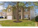 Charming two-story home with brick and vinyl siding, showcasing a well-maintained front yard and mature tree at 707 Sinclair Dr, Monroe, NC 28112