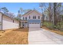 Two story home with light blue and gray siding, concrete driveway, and attached two car garage at 7444 Malabar Rd # 14, Huntersville, NC 28078
