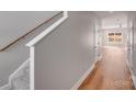 Hallway featuring wood floors and white staircase leading to the second floor at 7444 Malabar Rd # 14, Huntersville, NC 28078
