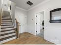 Bright foyer with hardwood floors, stairs with wood handrail, and white trimwork throughout at 8707 Nolley Ct, Charlotte, NC 28270