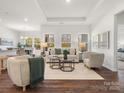 Bright living room featuring hardwood floors, tray ceiling, neutral decor, and abundant natural light at 1026 Mapletree Ln, Indian Trail, NC 28079