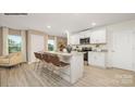 Bright kitchen features stainless appliances, white cabinets, granite countertops, and seating at the island at 1036 Hostler Ln, York, SC 29745