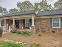 Charming brick home boasts a cozy front porch with stone accents, a covered entrance, and lush landscaping at 1340 Braeburn Rd, Charlotte, NC 28211