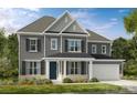 Charming two-story home with a gray exterior, well-manicured lawn, and attached two-car garage at 13408 Chopin Ridge Rd, Huntersville, NC 28078