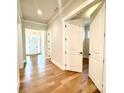 Bright hallway featuring hardwood floors, a doorway to the office, and a view of the entrance at 174 Fulworth Nw Dr # 65, Concord, NC 28027