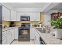 Well-lit kitchen boasts white cabinetry, granite countertops, and stainless steel appliances at 1832 J Julian Ln # D, Charlotte, NC 28208