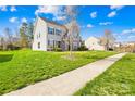 Spacious home showcasing a lush front yard, tree-lined street, and charming architectural details at 2146 Holden Sw Ave, Concord, NC 28025