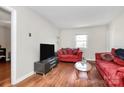 Cozy living room with hardwood floors, bright window, and comfortable seating at 2629 Vail Ave, Charlotte, NC 28204