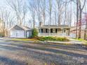 View of home and detached two-car garage, and gravel driveway, surrounded by mature trees at 300 Boyd Rd, Clover, SC 29710