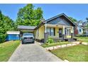 The front exterior reveals a well-manicured lawn, driveway, and stylish yellow home with a covered carport at 302 Griffith Rd, Monroe, NC 28112