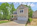 Charming two-story home featuring a covered porch, attached two-car garage, and professionally landscaped yard at 3204 Leah Elizabeth Ln, Monroe, NC 28110