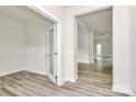An empty room with light colored laminate flooring, neutral walls and white trim, with an open doorway at 3204 Leah Elizabeth Ln, Monroe, NC 28110