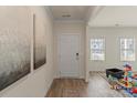 Inviting foyer features hardwood floors, a white front door, and is brightly lit from the sidelight windows at 4104 Armstrong Farm Dr, Belmont, NC 28012