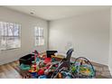 Brightly lit room with hardwood flooring, two windows and containing a number of toys and baby accessories at 4104 Armstrong Farm Dr, Belmont, NC 28012
