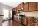 Well-equipped kitchen features stainless steel appliances, dark cabinetry, and hardwood floors at 4644 Craigmoss Ln, Charlotte, NC 28278