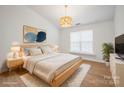 Bright bedroom features a large window, modern light fixture, and hardwood floors at 5291 Moonlight Sw Trl, Concord, NC 28025