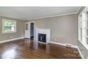 Bright living room with hardwood floors, a brick fireplace, and ample natural light from large windows at 5323 Hilltop Cir, Charlotte, NC 28269