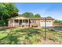 Charming brick home featuring a welcoming front porch, manicured lawn, and a two-car garage at 552 Odell School Rd, Concord, NC 28027