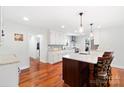 Bright, open kitchen with island seating, sleek countertops, and modern lighting fixtures at 552 Odell School Rd, Concord, NC 28027