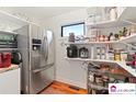 Pantry with stainless steel fridge, and shelving stocked with food and cooking supplies at 552 Odell School Rd, Concord, NC 28027