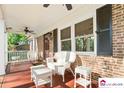Cozy covered front porch with white wicker furniture, ceiling fan, and charming details at 552 Odell School Rd, Concord, NC 28027