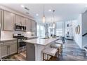 Open-concept kitchen features a large island with seating and stainless steel appliances at 6250 Tea Olive Dr # 240, Harrisburg, NC 28075
