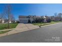 Inviting two-story home with an attached garage, solar panels, a front porch, and a well-manicured lawn at 6308 Brumit Ln, Charlotte, NC 28269