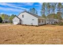 Side-rear view of home with a two-car garage, a lawn area, and a well-maintained yard at 700 Sunset Pointe Dr, Salisbury, NC 28146