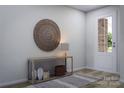 Inviting entryway with decorative table, round wall decor, and a view of the outdoors at 7027 Short Stirrup Ln, Mint Hill, NC 28227