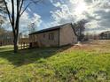 Back exterior featuring a brick home with a deck and sunny backyard, perfect for outdoor living at 1112 Sedgewood Ln, Lincolnton, NC 28092