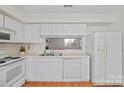 Bright kitchen features white cabinetry, tile countertops, and an open layout into the living area at 1205 Scaleybark Rd # A, Charlotte, NC 28209