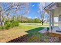 Inviting porch view of a home's exterior with a well-maintained lawn and blossoming trees beyond at 130 Atwell Rd, Mt Ulla, NC 28125