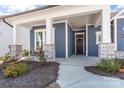 Inviting covered front porch, stone accents and beautiful landscaping enhance curb appeal at 1447 Encore Ln, Waxhaw, NC 28173