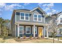 Attractive two-story home with a bright yellow door, complemented by blossoming trees at 15616 Parkside Crossing Dr, Charlotte, NC 28278