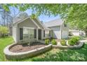 Well-maintained house featuring stone-lined flower beds and lush green lawn at 1838 Summit Ridge Ln, Kannapolis, NC 28083