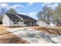 A cozy light-gray home featuring a concrete driveway and well-maintained yard under a beautiful sky at 206 W 19Th St, Kannapolis, NC 28081