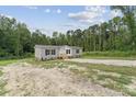 Quaint single-story home with a gravel driveway, surrounded by trees and natural landscaping at 253 Artemis Pl # 27, Kershaw, SC 29067