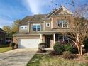 Inviting two-story home boasts a well-manicured lawn, brick and siding accents, and an attached two-car garage at 2741 Smethwick Ln, Gastonia, NC 28056