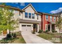 Charming townhome with attached garage, stone accents and landscaped yard on a beautiful partially cloudy day at 319 Pond Place Ln, Matthews, NC 28104