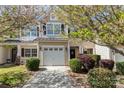 Charming townhouse with a white garage door, manicured landscaping, and flowering trees in the front yard at 321 Rose Garden Ct, Rock Hill, SC 29732